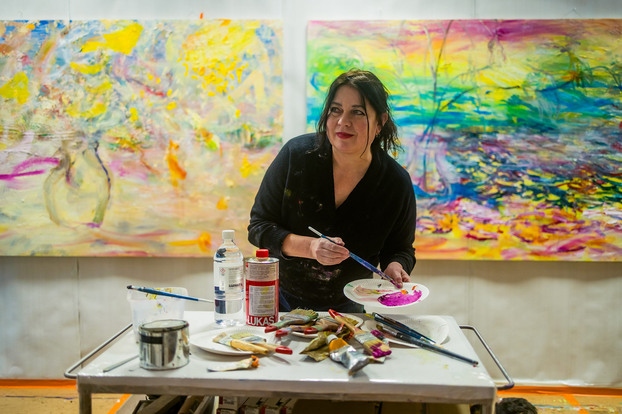 Nanna Susi at her studio with palette and paintings
